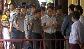 Reuters journalist Wa Lone, center, is escorted by polices upon arrival at the court Monday, Sept. 3, 2018, in Yangon, Myanmar. A Myanmar court sentenced two Reuters journalists, Wa Lone and Kyaw Soe Oo, to seven years in prison Monday for illegal possession of official documents, a ruling that comes as international criticism mounts over the military&#39;s alleged human rights abuses against Rohingya Muslims.  (AP Photo/Thein Zaw)