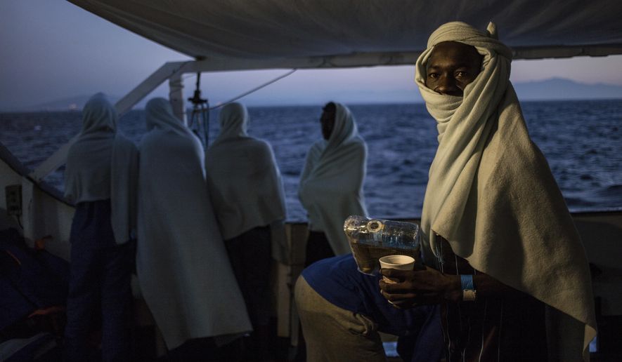 FILE - In this Thursday, Aug. 9, 2018 file photo, migrants stand on the deck of the Open Arms boat, after being rescued off the coast of Libya in the early hours of the night of Thursday, Aug. 2, 2018. The U.N. refugee agency says people smugglers are taking greater risks to ferry their human cargo toward Europe as Libya’s coast guard increasingly intercepts boats carrying migrants, increasing the likelihood that those on board may die on the Mediterranean journey. That’s one of the key findings from the latest UNHCR report about efforts to reach Europe. (AP Photo/Valerio Nicolosi, File)