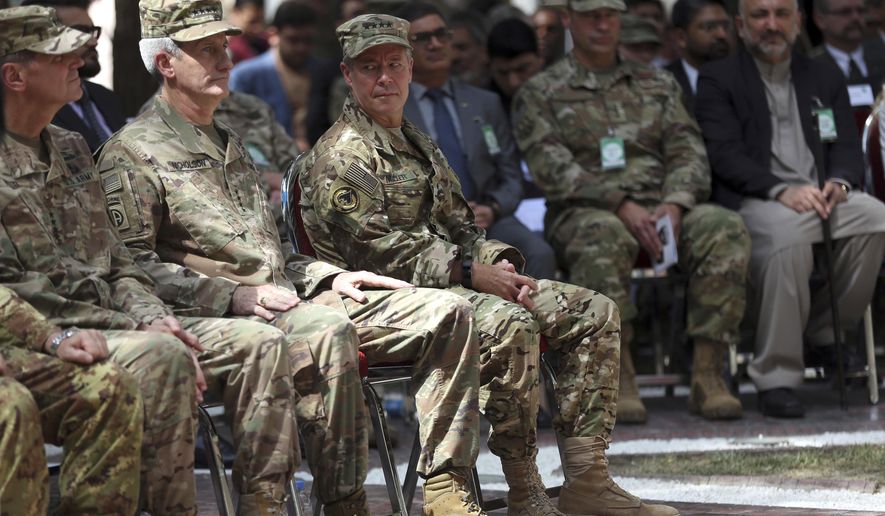 Outgoing U.S. Army Gen. John Nicholson, second from left, listens as incoming U.S. Army Gen. Austin Miller, third from left, looks at him before the change of command ceremony starts at Resolute Support headquarters, in Kabul, Afghanistan, Sunday, Sept. 2, 2018. Miller has assumed command of the 41-nation NATO mission in Afghanistan following a handover ceremony. A U.S. service member has been killed and another wounded in an apparent insider attack in eastern Afghanistan. In a statement Monday, Miller says "the sacrifice of our service member, who volunteered for a mission to Afghanistan to protect his country is a tragic loss for all who knew and all who will now never know him." He added, "Our duty now is to honor him, care for his family and continue our mission." (AP Photo/Massoud Hossaini)