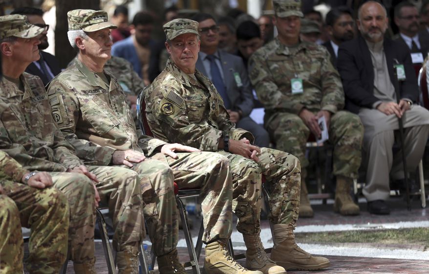 Outgoing U.S. Army Gen. John Nicholson, second from left, listens as incoming U.S. Army Gen. Austin Miller, third from left, looks at him before the change of command ceremony starts at Resolute Support headquarters, in Kabul, Afghanistan, Sunday, Sept. 2, 2018. Miller has assumed command of the 41-nation NATO mission in Afghanistan following a handover ceremony. A U.S. service member has been killed and another wounded in an apparent insider attack in eastern Afghanistan. In a statement Monday, Miller says "the sacrifice of our service member, who volunteered for a mission to Afghanistan to protect his country is a tragic loss for all who knew and all who will now never know him." He added, "Our duty now is to honor him, care for his family and continue our mission." (AP Photo/Massoud Hossaini)