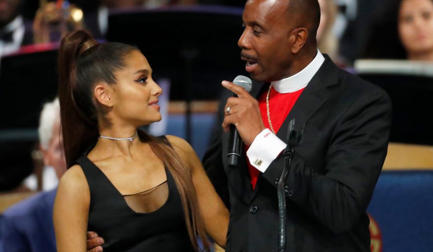 Bishop Charles H. Ellis III, right, speaks with Ariana Grande after she performed during the funeral service for Aretha Franklin at Greater Grace Temple, Friday, Aug. 31, 2018, in Detroit. Franklin died Aug. 16, 2018, of pancreatic cancer at the age of 76. (AP Photo/Paul Sancya)