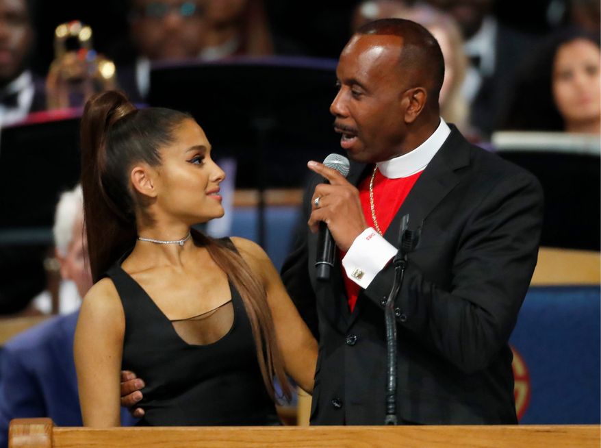 Bishop Charles H. Ellis III, right, speaks with Ariana Grande after she performed during the funeral service for Aretha Franklin at Greater Grace Temple, Friday, Aug. 31, 2018, in Detroit. Franklin died Aug. 16, 2018, of pancreatic cancer at the age of 76. (AP Photo/Paul Sancya)