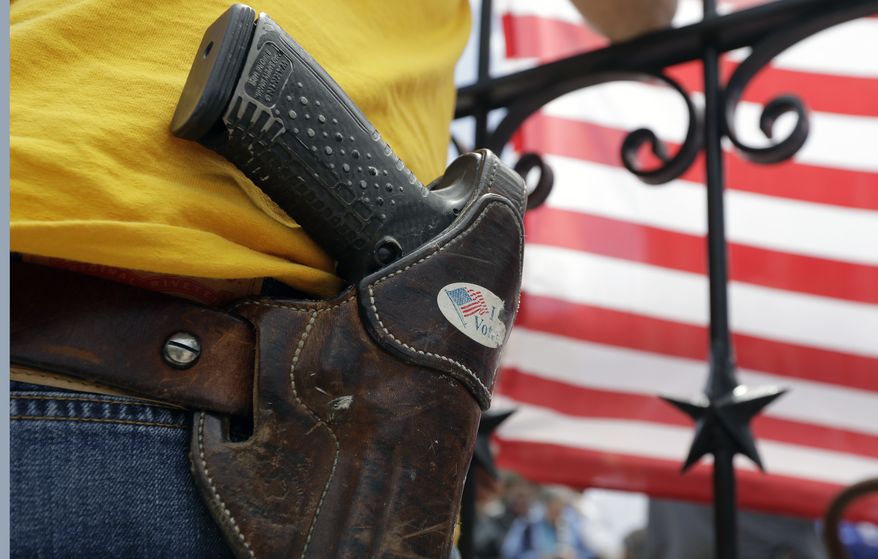 A man wears an unloaded pistol during a pro gun-rights rally at the state capitol, Saturday, April 14, 2018, in Austin, Texas. Gun rights supporters rallied across the United States to counter a recent wave of student-led protests against gun violence. (AP Photo/Eric Gay)