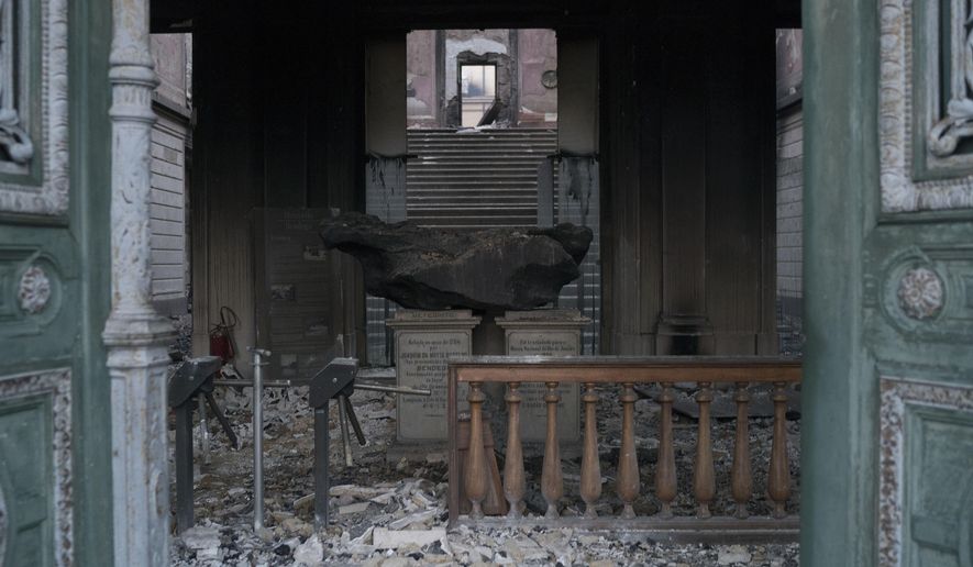 A meteorite on exhibit at the National Museum is seen through a door after an overnight fire in Rio de Janeiro, Brazil, Monday, Sept. 3, 2018. Firefighters dug through the burned-out hulk of Brazil’s National Museum on Monday, a day after fire gutted the building, as the country mourned the irreplaceable treasures lost and pointed fingers over who was to blame. (AP Photo/Leo Correa)