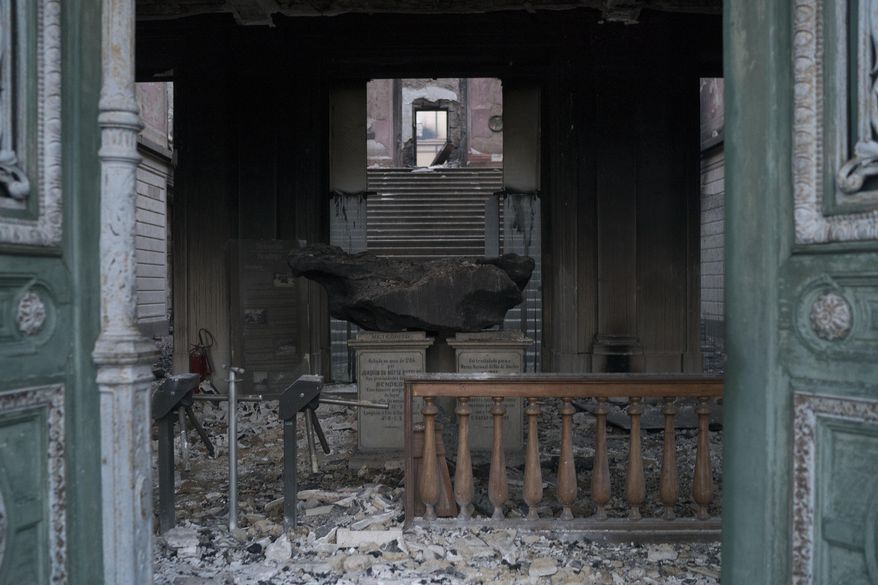 A meteorite on exhibit at the National Museum is seen through a door after an overnight fire in Rio de Janeiro, Brazil, Monday, Sept. 3, 2018. Firefighters dug through the burned-out hulk of Brazil’s National Museum on Monday, a day after fire gutted the building, as the country mourned the irreplaceable treasures lost and pointed fingers over who was to blame. (AP Photo/Leo Correa)