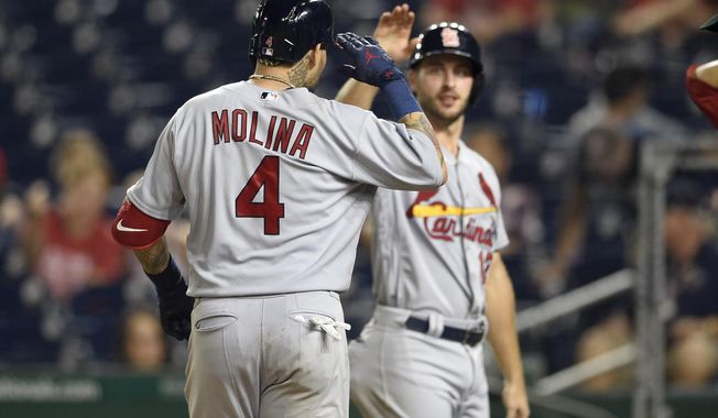 St. Louis Cardinals&#x27; Yadier Molina (4) celebrates his grand slam with Paul DeJong, back, during the ninth inning of a baseball game against the Washington Nationals, Tuesday, Sept. 4, 2018, in Washington. The Cardinals won 11-8. (AP Photo/Nick Wass)