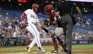 Washington Nationals&#x27; Bryce Harper (34) reacts after he was tagged out at home by St. Louis Cardinals catcher Yadier Molina, center, as home plate umpire CB Bucknor, right, watches during the first inning of a baseball game, Wednesday, Sept. 5, 2018, in Washington. (AP Photo/Nick Wass)