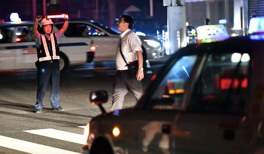 A police officer controls the traffic during a blackout following a strong earthquake in Sapporo, northern Japan early Thursday, Sept. 6, 2018.  A powerful earthquake struck the island of Hokkaido early Thursday. (Yu Nakajima/Kyodo News via AP)