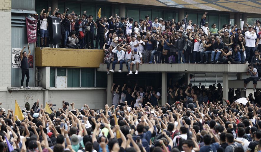 Thousands of students at Mexico's National Autonomous University protest to demand an end to violence by groups of thugs known as "porros," who are often registered but don't attend classes, at the University's main campus in Mexico City, Wednesday, Sept. 5, 2018. Students at Mexico's largest university have gone on strike after a campus attack against protestors on Monday, in which two students were seriously injured. (AP Photo/Rebecca Blackwell)