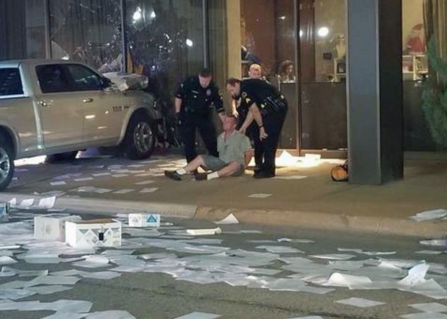 In this image taken from video by KDFW Fox 4 a man is detained after crashing his pickup truck into the side of the Fox affiliate television station building in downtown Dallas on Wednesday, Sept. 5, 2018. Despite the crash, nobody was hurt. (KDFW Fox 4 via AP)