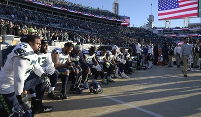 Seattle Seahawks players kneel during the national anthem before an NFL football game against the Jacksonville Jaguars, Sunday, Dec. 10, 2017, in Jacksonville, Fla. (AP Photo/Phelan M. Ebenhack)