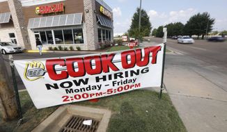 In this is a July 25, 2018, photo cars drive by a help wanted sign at a Cook Out fast food restaurant in Jackson, Miss. On Thursday, Sept. 6, payroll processor ADP reports how many jobs private employers added in August. (AP Photo/Rogelio V. Solis)