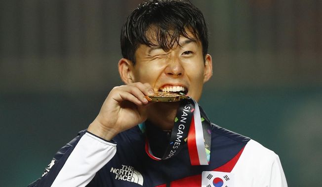 South Korea&#x27;s Son Heung-min celebrates on the podium after defeating Japan in the  men&#x27;s soccer gold medal match at the 18th Asian Games in Bogor, Indonesia, Saturday, Sept. 1, 2018. (AP Photo/Bernat Armangue)
