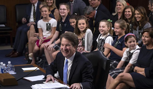 Supreme Court nominee Brett Kavanaugh smiles as he is visited by young student athletes he coaches over the years, as he testifies before the Senate Judiciary Committee on the third day of his confirmation hearing, on Capitol Hill in Washington, Thursday, Sept. 6, 2018. (AP Photo/J. Scott Applewhite)