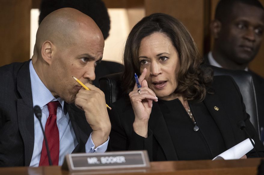 Sen. Cory Booker, D-N.J., left, and Sen. Kamala Harris, D-Calif., confer as Supreme Court nominee Brett Kavanaugh testifies before the Senate Judiciary Committee on the third day of his confirmation hearing, on Capitol Hill in Washington, Thursday, Sept. 6, 2018. (AP Photo/J. Scott Applewhite)