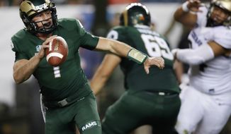 FILE--In this Friday, Aug. 31, 2018, file photograph, Colorado State quarterback K.J. Carta-Samuels rolls out to pass under pressure during the second half of an NCAA college football game against Colorado in Denver. Colorado won 45-13. Carta-Samuels and the Rams will host Arkansas on Saturday. (AP Photo/David Zalubowski, File)