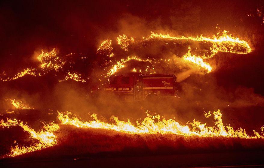 Flames from a backfire burn around a fire truck battling the Delta Fire in the Shasta-Trinity National Forest, Calif., on Thursday, Sept. 6, 2018. (AP Photo/Noah Berger)