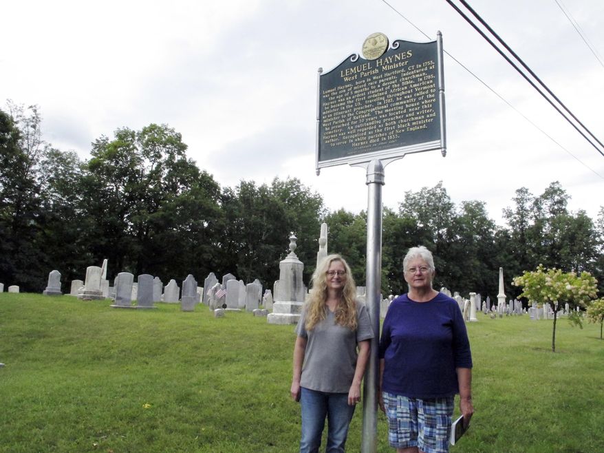 In this Sept. 6, 2018, photo, Michelle Jagodzinski, left, and Mary Reczek, right, of the West Rutland Historical Society in Vermont stand next to a new historical marker honoring Lemuel Haynes, first ordained black minister in the U.S. in West Rutland, Vt. (AP Photo/Lisa Rathke)