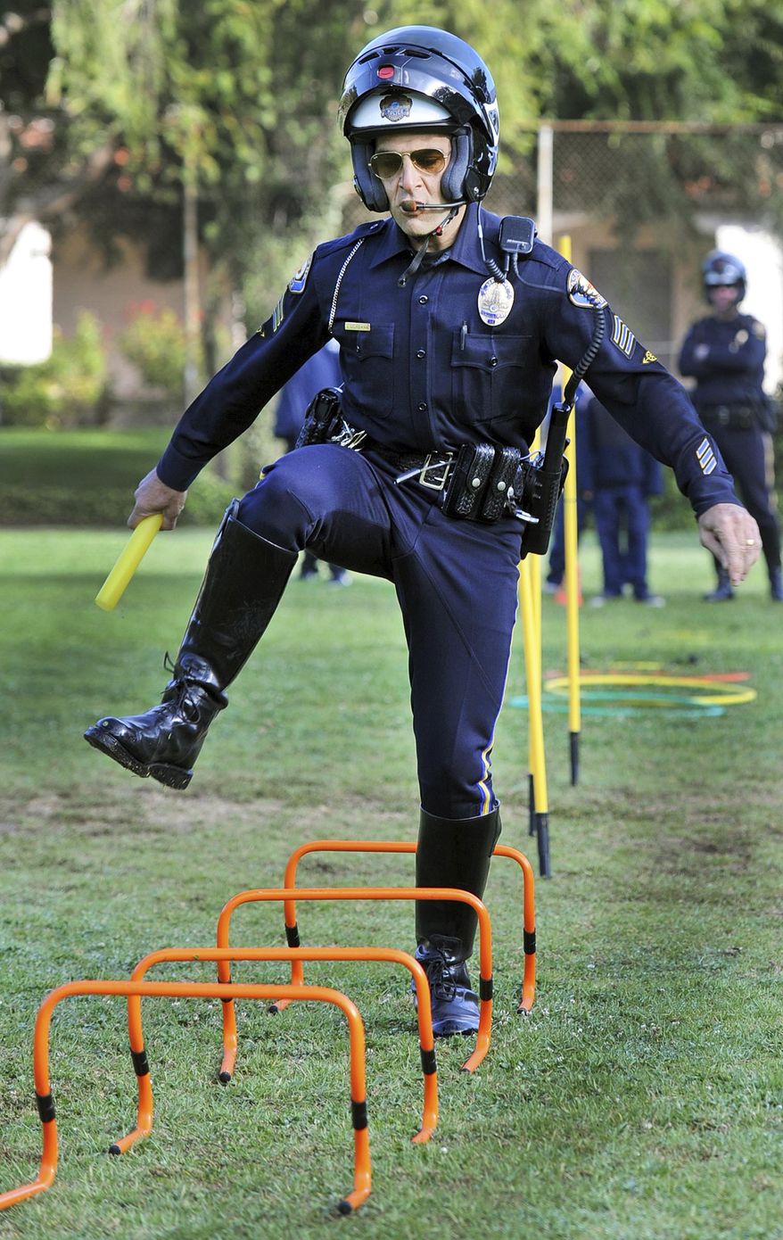 FILE - In this Oct. 6, 2011, file photo, then Pasadena Police officer Sgt. Vasken Gourdikian pariticpates in the Relay Race with students against Pasadena Firefighters and students at Madison Elementary in Pasadena, Calif. The former Southern California police lieutenant who also acted as a department spokesman has agreed to plead guilty in connection with the illegal sale of more than 100 guns, prosecutors said Friday, Sept. 7, 2018. Former Pasadena Police Lt. Gourdikian of Sierra Madre, Calif., signed an agreement with prosecutors to plead guilty on Sept. 20 to dealing in firearms without a license and lying during a gun purchase. (Walt Mancini/The Orange County Register via AP, File)