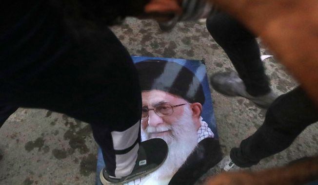 Protesters trample a portrait of Iran&#x27;s supreme Leader Ayatollah Ali Khamenei, during the storming and burning the Iranian consulate in Basra, 340 miles (550 km) southeast of Baghdad, Iraq, Friday, Sept. 7, 2018. Hundreds of angry protesters in Basra took to the streets on Thursday night. Some clashed with security forces, lobbing Molotov cocktails and setting fire to a government building as well as the offices of Shiite militias. At least three people were shot dead in confrontations with security forces. (AP Photo/Nabil al-Jurani)