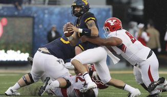 West Virginia quarterback Will Grier (7) is sacked by Youngstown State defensive tackle Wesley Thompson Wesley during the first half of an NCAA college football game Saturday, Sept. 8, 2018, in Morgantown, W.Va. (AP Photo/Raymond Thompson)