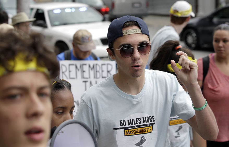 David Hogg, center, a survivor of the school shooting at Marjory Stoneman Douglas High School, in Parkland, Florida, walks in a planned 50-mile march, Thursday, Aug. 23, 2018, in Worcester, Mass. The march, held to call for gun law reforms, began Thursday, in Worcester, and is scheduled to end Sunday, Aug. 26, 2018, in Springfield, Mass., at the headquarters of gun manufacturer Smith &amp; Wesson. (AP Photo/Steven Senne)