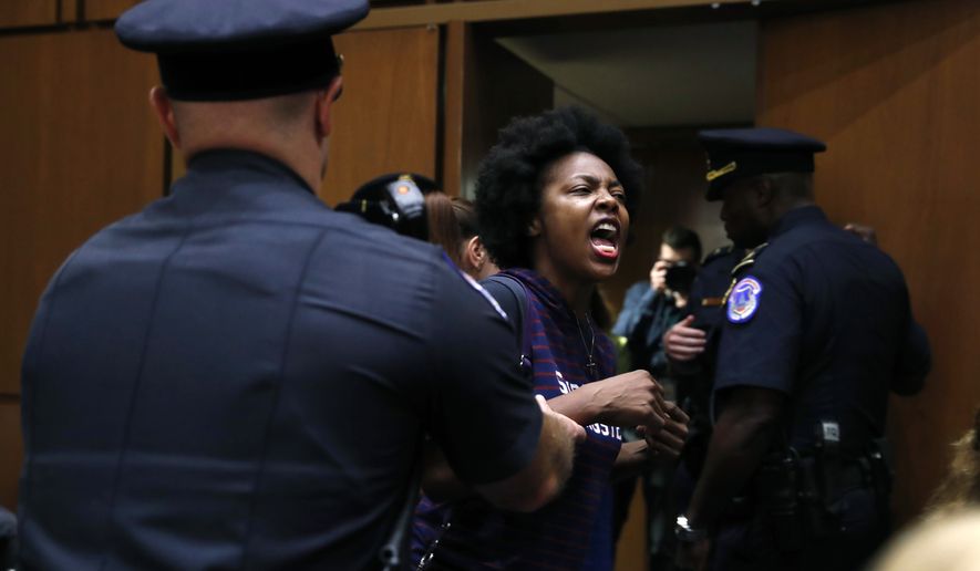 A protester against Supreme Court nominee Brett Kavanaugh is removed from his Senate Judiciary Committee confirmation hearing, on Capitol Hill, Tuesday, Sept. 4, 2018, in Washington. (AP Photo/Jacquelyn Martin)