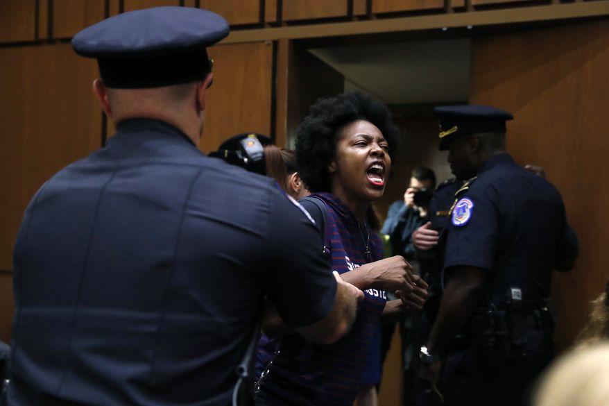 A protester against Supreme Court nominee Brett Kavanaugh is removed from his Senate Judiciary Committee confirmation hearing, on Capitol Hill, Tuesday, Sept. 4, 2018, in Washington. (AP Photo/Jacquelyn Martin)