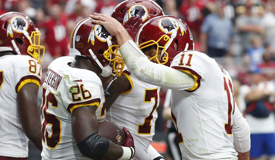 Washington Redskins running back Adrian Peterson (26) celebrates his touchdown run with quarterback Alex Smith (11) during the first half of an NFL football game against the Arizona Cardinals, Sunday, Sept. 9, 2018, in Glendale, Ariz. (AP Photo/Rick Scuteri)