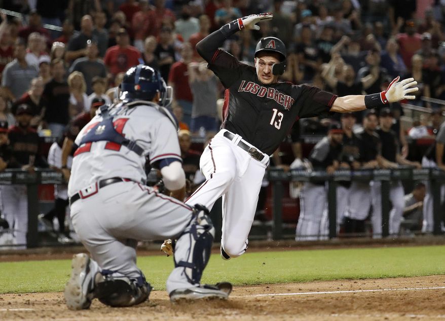 Arizona Diamondbacks Nick Ahmed (13) is tagged out at the plate by Atlanta Braves catcher Kurt Suzuki to end the baseball game Saturday, Sept. 8, 2018, in Phoenix. The Braves won 5-4 in 10 innings. (AP Photo/Matt York)