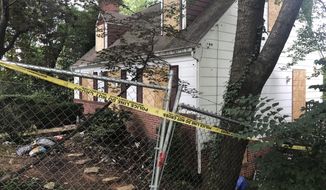 In this Aug. 18, 2018, photo, police tape surrounds the house where Askia Khafra died in a fire while digging underground tunnels for a secretive campaign to build a nuclear bunker in Bethesda, Md. Daniel Beckwitt, a stock trader who lived alone in the house, is charged with second-degree murder and involuntary manslaughter in the Sept. 10, 2017, death of Askia Khafra. (AP Photo/Michael Kunzelman)