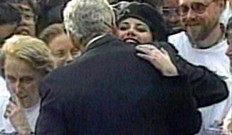In this image taken from video, Monica Lewinsky embraces President Clinton as he greeted well-wishers at a White House lawn party in Washington Nov. 6, 1996. (AP Photo/APTV)