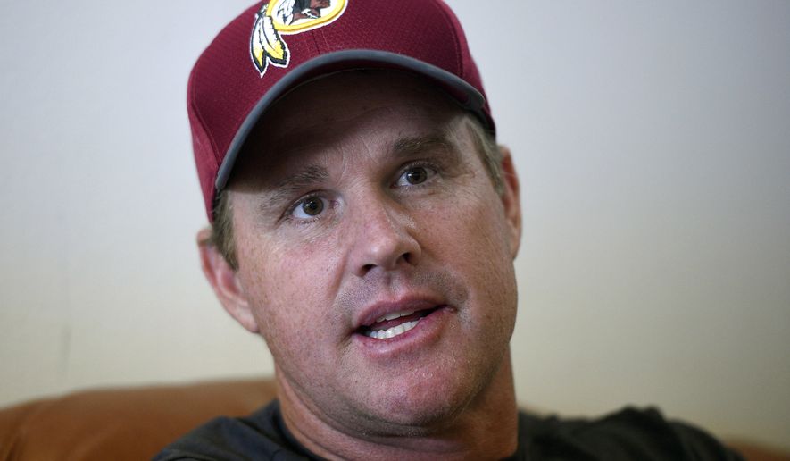 Washington Redskins head coach Jay Gruden speaks as he is interviewed by the Associated Press after an NFL football team practice, Wednesday, June 13, 2018, in Ashburn, Va. The Gruden brothers are set to do something only one other family has done in NFL history. With Jon Gruden leaving the TV booth to return to the sideline for a second stint as coach of the Oakland Raiders and Jay Gruden entering his fifth year with the Washington Redskins, the Grudens will join the Harbaughs as the only sets of siblings to simultaneously hold jobs as NFL head coaches.  (AP Photo/Nick Wass)