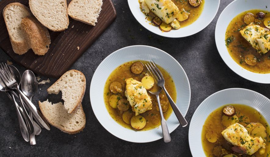This undated photo provided by America's Test Kitchen in August 2018 shows cod in saffron broth with chorizo and potatoes in Brookline, Mass. This recipe appears in the cookbook “Dinner Illustrated.” (Steve Klise/America's Test Kitchen via AP)