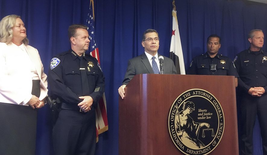 California Attorney General, Xavier Becerra, at podium, and other officials announce indictments of 32 members of purported street gangs on charges of stealing more than $1 million using an unusually sophisticated credit card fraud, at a news conference in Sacramento, Calif., Monday, Sept. 10, 2018. From left are Deputy Attorney General Tawnya Austin, who heads the attorney general's e-crimes unit; Walnut Creek Police Chief Tom Chaplin; Becerra; Sacramento Police Chief Daniel Hahn; and Vacaville Police Chief John Carli. Authorities said Monday that the BullyBoys and the CoCo Boys street gangs defrauded hundreds of victims across Northern California by breaking into dozens of medical and dental offices to steal credit card terminals and patient records. (AP Photo/Don Thompson)