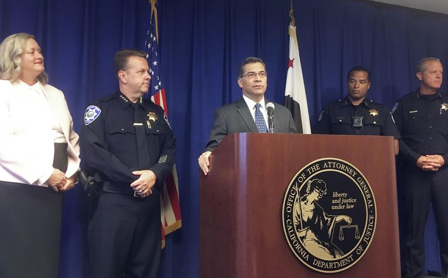California Attorney General, Xavier Becerra, at podium, and other officials announce indictments of 32 members of purported street gangs on charges of stealing more than $1 million using an unusually sophisticated credit card fraud, at a news conference in Sacramento, Calif., Monday, Sept. 10, 2018. From left are Deputy Attorney General Tawnya Austin, who heads the attorney general's e-crimes unit; Walnut Creek Police Chief Tom Chaplin; Becerra; Sacramento Police Chief Daniel Hahn; and Vacaville Police Chief John Carli. Authorities said Monday that the BullyBoys and the CoCo Boys street gangs defrauded hundreds of victims across Northern California by breaking into dozens of medical and dental offices to steal credit card terminals and patient records. (AP Photo/Don Thompson)