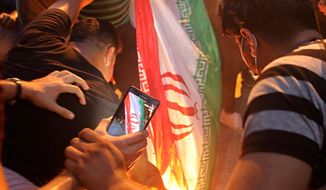 In this Friday, Sept. 7, 2018 file photo, protesters burn an Iranian flag after storming and burning the Iranian consulate building in Basra, Iraq.  (AP Photo/Nabil al-Jurani, File) **FILE**