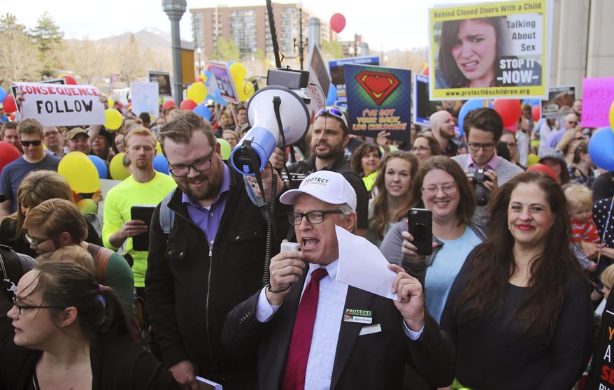 FILE - In this March 30, 2018, file photo, Sam Young, center, speaks to a group of people during a march to church headquarters, in Salt Lake City. Young, a Mormon who has led a campaign criticizing the church's practice of allowing closed-door, one-on-one interviews of youth by lay leaders, will have to wait to find out if he'll be kicked out of the religion. Young said late Sunday, Sept. 9, 2018, that local church leaders didn't make a decision following a disciplinary council at his congregation in Houston. Young says they didn't say when they will decide. (AP Photo/Rick Bowmer, File)