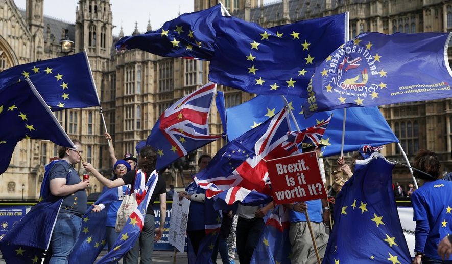 Remain supporters holds up a placards and flags of United Kingdom and the European Union outside The Palace of Westminster to show their support for 'Stopping Brexit' in London, Monday, Sept. 10, 2018. (AP Photo/Alastair Grant)