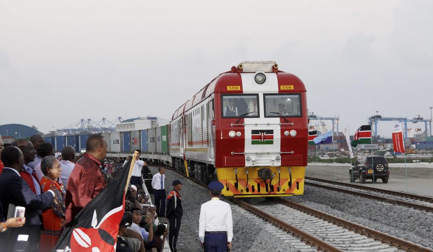 FILE - In this May 30, 2017, file photo, Kenyan President Uhuru Kenyatta, 3rd left, watches during the opening of the SGR cargo train runs on a China-backed railway from the port containers depot in Mombasa Kenya, to Nairobi. A wave of Chinese-financed railways and other trade links in Africa and Asia that have prompted worries about debt and Beijing's ambitions is reducing politically dangerous inequality between regions within countries, a multinational group of researchers said Tuesday, Sept. 11, 2018. (AP Photo/Khalil Senosi, File) **FILE**