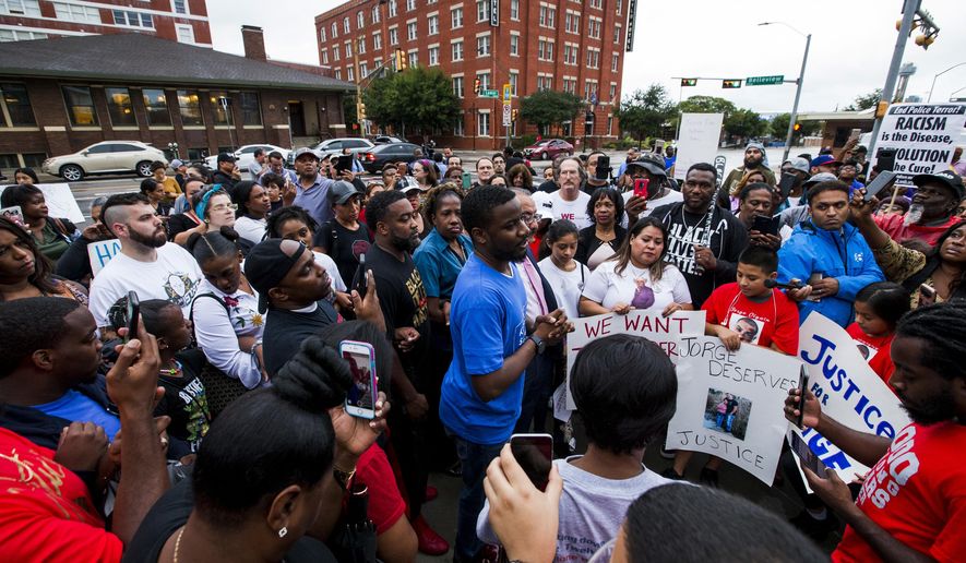 Protesters in the shooting death of Botham Jean, gather at the Jack Evans Police Headquarters, Monday, Sept. 10, 2018 in Dallas. Jean was shot Thursday by off-duty Dallas police officer Amber Guyger, who says she mistook his apartment for hers. (Shaban Athuman /The Dallas Morning News via AP)