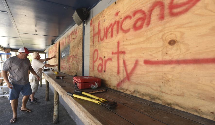 Jim Carter and Rob Quinn board up Lagerheads Tavern in Wrightsville Beach, N.C. as they prepare for Hurricane Florence Monday, Sept. 10, 2018. Hurricane Florence now a category 3 hurricane is expected to make land fall somewhere along the North Carolina coastline towards the end of the week. (Ken Blevins /The Star-News via AP)