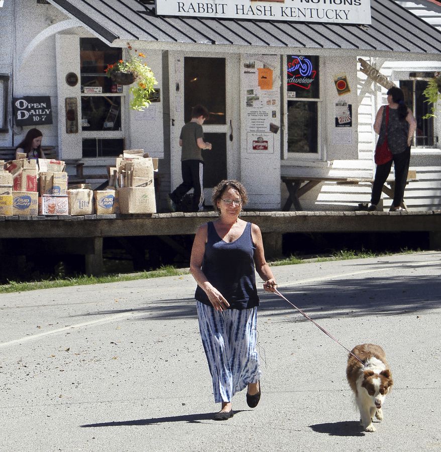 In this Aug. 24, 2015, file photo, Rabbit Hash Mayor Lucy Lou takes her owner, Bobbi Layne Kayser, on a walk through her jurisdiction, in Rabbit Hash, Ky. The Enquirer reports Rabbit Hash’s first female mayor, Lucy Lou, died Monday, Sept. 10, 2018. She was 12, and a dog. (Patrick Reddy/The Cincinnati Enquirer via AP)/The Cincinnati Enquirer via AP)