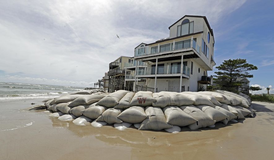 Sand bags surround homes on North Topsail Beach, N.C., Wednesday, Sept. 12, 2018, as Hurricane Florence threatens the coast. (AP Photo/Chuck Burton)