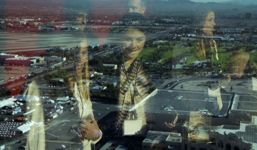 FILE- In this Oct. 23, 2014, file photo people are reflected in a window at the Delano Las Vegas overlooking the Las Vegas Valley in Las Vegas. The income of a median U.S. household rose for a third straight year in 2017, boosted by a rise in the number of Americans with full-time jobs. (AP Photo/John Locher, File)