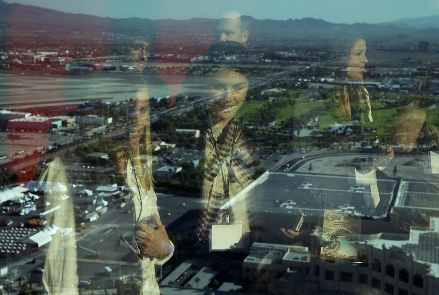 FILE- In this Oct. 23, 2014, file photo people are reflected in a window at the Delano Las Vegas overlooking the Las Vegas Valley in Las Vegas. The income of a median U.S. household rose for a third straight year in 2017, boosted by a rise in the number of Americans with full-time jobs. (AP Photo/John Locher, File)
