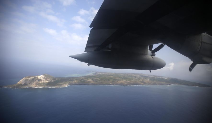 FILE - In this March 21, 2015, file photo, Iwo Jima, now known officially as Ioto, is seen from an airplane in Japan. Japan’s Meteorological Agency said Wednesday, Sept. 12, 2018, aerial photos detected signs of undersea volcanic eruptions off the southern coast of Iwo Jima, the site of one of the bloodiest campaigns in the World War II. (AP Photo/Eugene Hoshiko, File)
