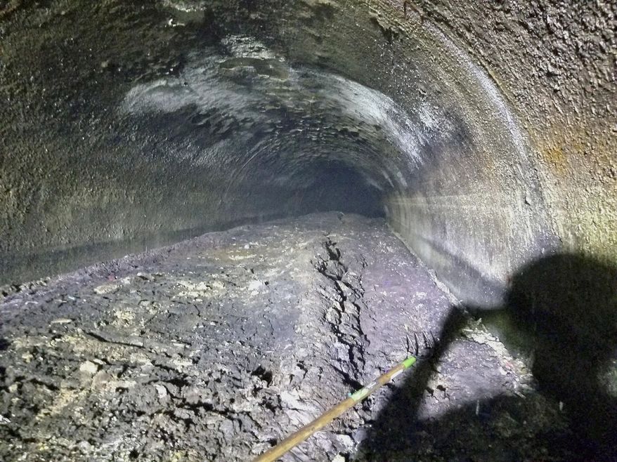 This Sept. 6, 2018 photo provided by the Macomb County Public Works Office shows a large fatberg in a sewer line in Clinton Township, Mich. The Macomb County Public Works Office says workers cleared the 11-foot-diameter pipe that was partially clogged by the collection of oils, grease, fat and solid items such as baby wipes. Officials hope the discovery of the fatberg will help educate the public about what shouldn't go down the drain. (Macomb County Public Works Office via AP)