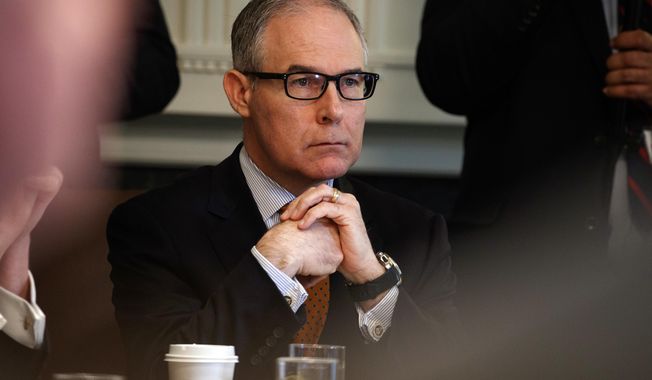 FILE - In this June 21, 2018, file photo, then-Environmental Protection Agency administrator Scott Pruitt listens as President Donald Trump speaks during a cabinet meeting at the White House in Washington. Pruitt, the scandal-plagued former chief of the EPA is denying he got any improper gifts on the job. The EPA on Wednesday, Sept. 12, released Pruitt’s financial disclosure report for 2017. The report requires Pruitt to disclose sources of income and any gifts.(AP Photo/Evan Vucci, File)