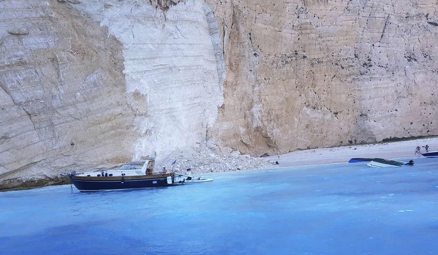 Small boats are capsized after a landslide occurred at the popular beach of Navagio, or Shipwreck Beach, on the western island of Zakynthos, Greece, Thursday, Sept. 13, 2018. Greek authorities say a landslide at a popular beach on the western island of Zakynthos has resulted in at least one injury, while coast guard officials were seeking to determine whether there were any people missing. (imerazante.gr via AP)